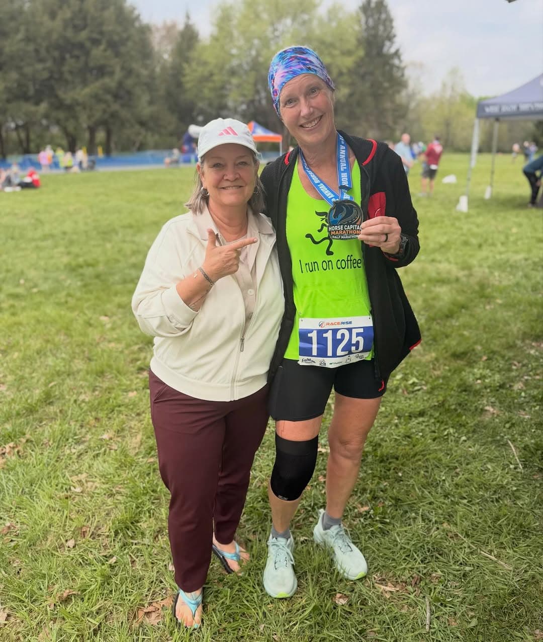 Finisher showing her Horse Capital Marathon medal at the finish festival