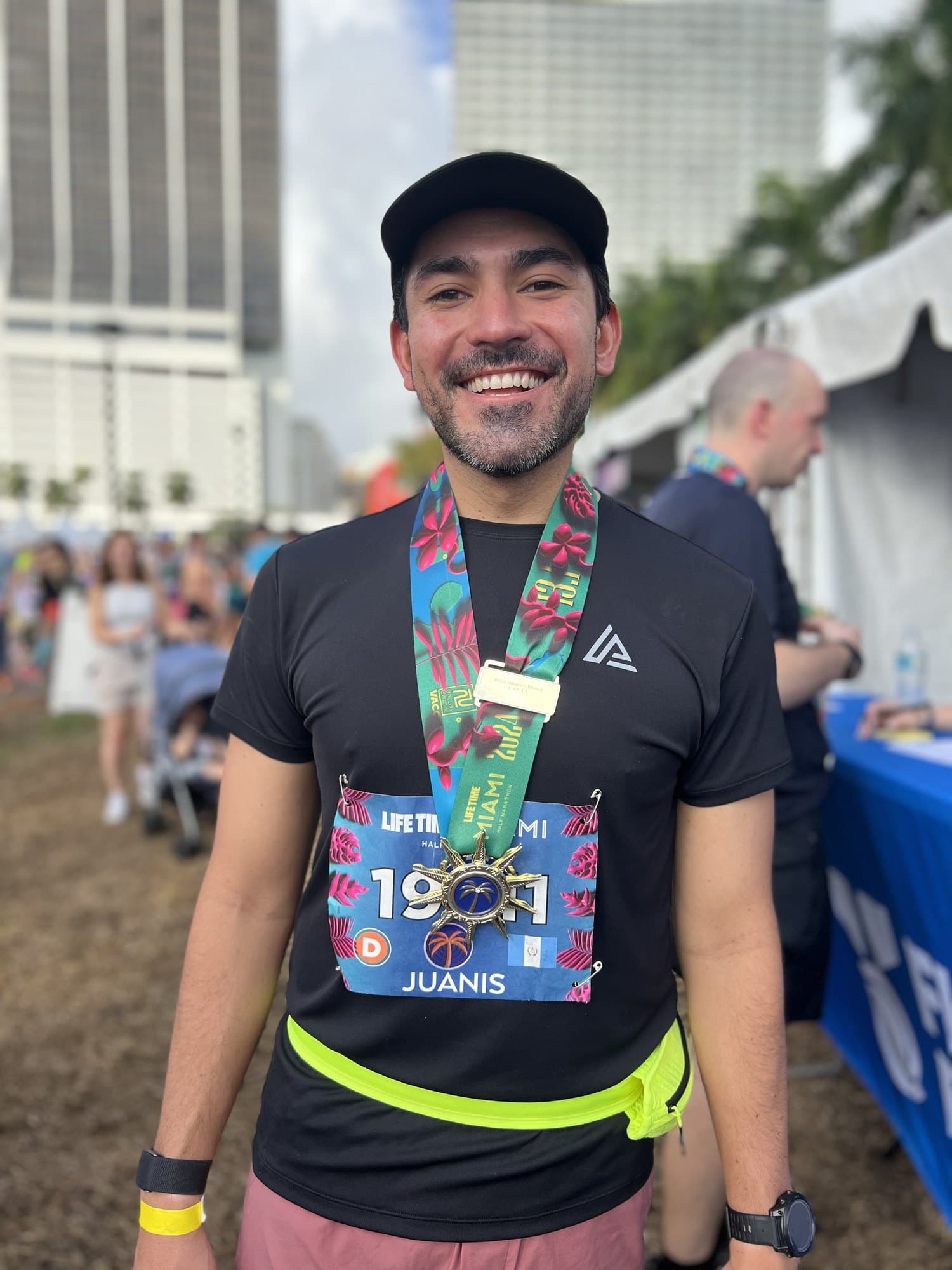 Finisher smiling with his engraved medal at the Life Time Miami Marathon finish festival