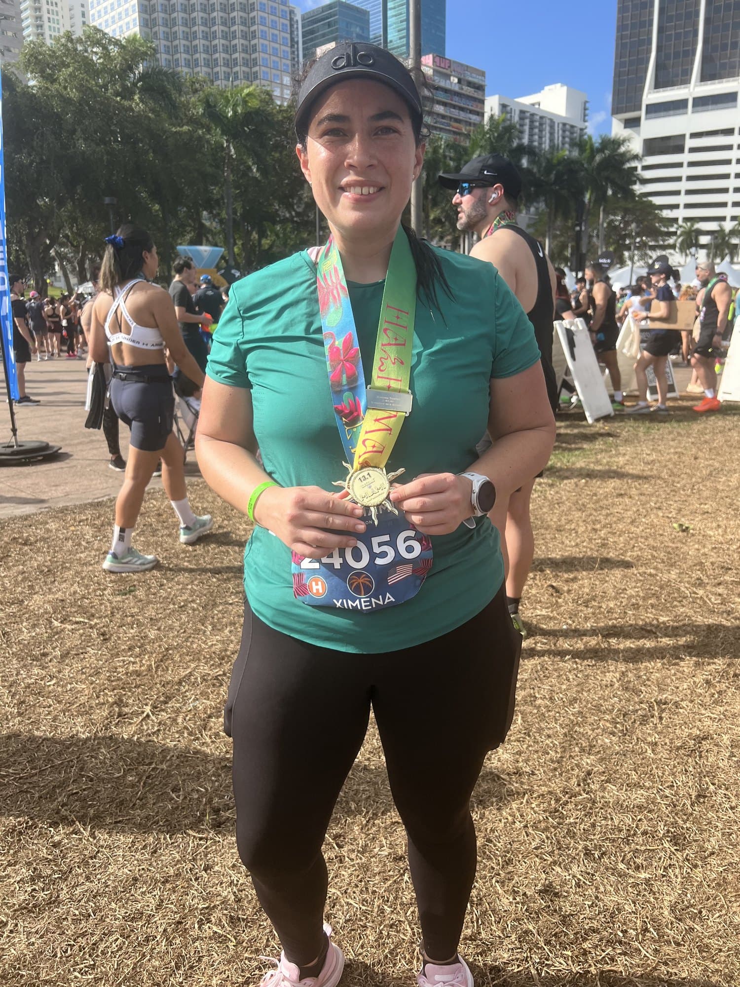A finisher smiling as she holds up her personalized engraved medal at the Life Time Miami Marathon