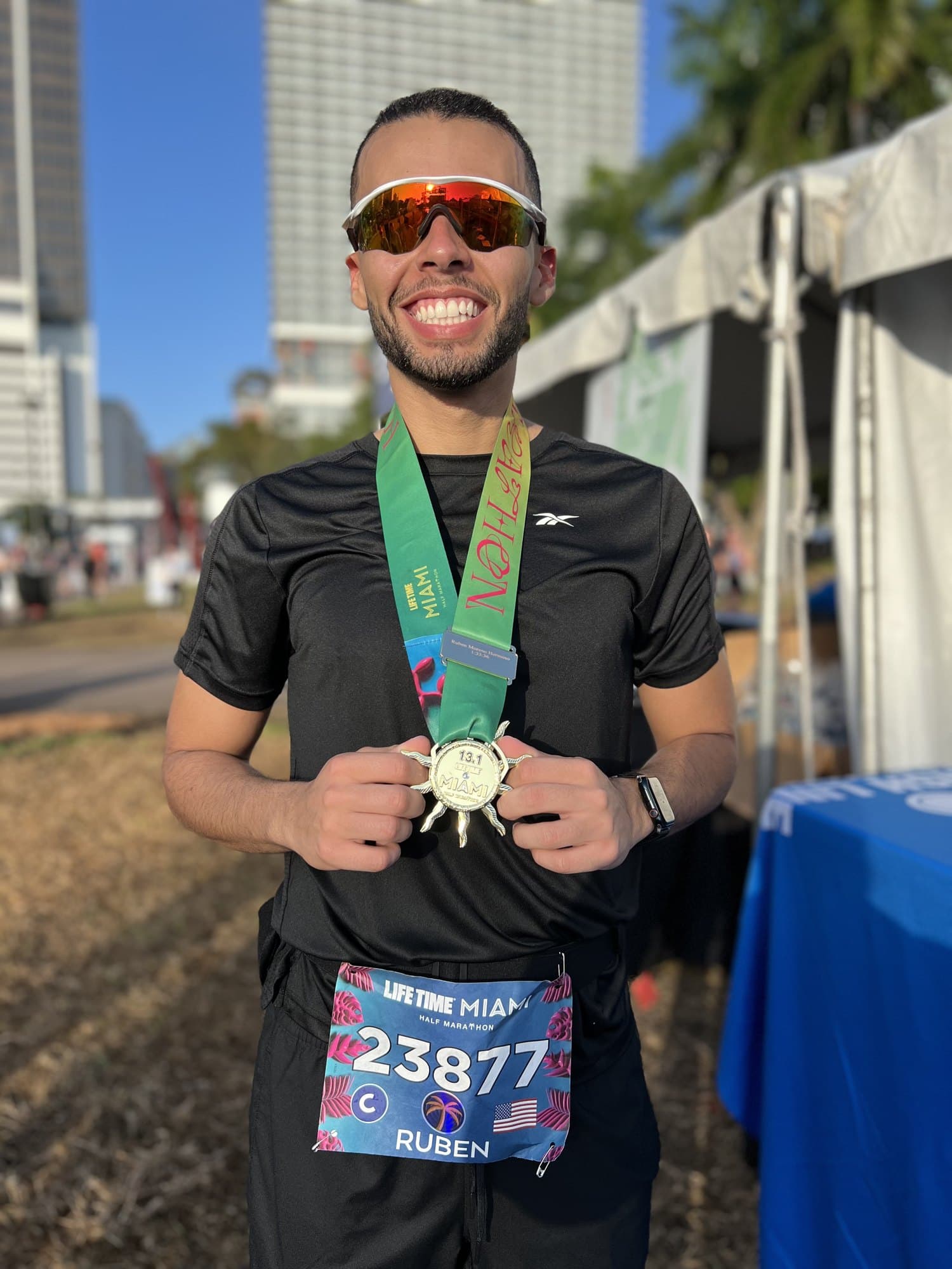 Finisher with her engraved Miami Marathon medal at the finish festival
