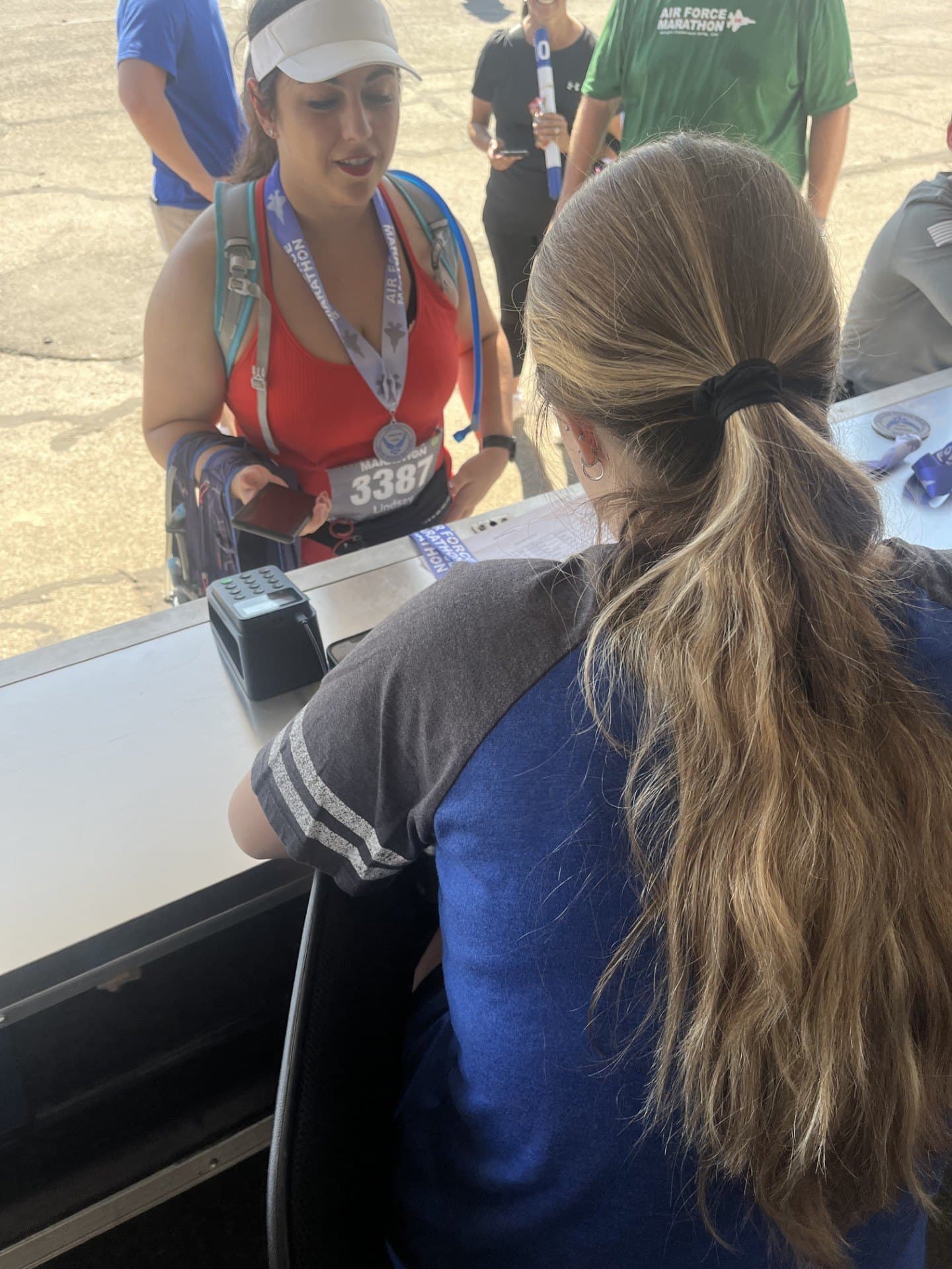 A Finish Line Engravers staff member personalizing a runner’s finisher medal at an on-site engraving station